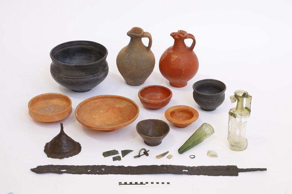 Grabinventar © Archäologisches Museum Frankfurt, Foto: Uwe Dettmar Mehrere Schalen und Amphoren in unterschiedlichen Größen und Farben und eine verrostete Schwertklinge