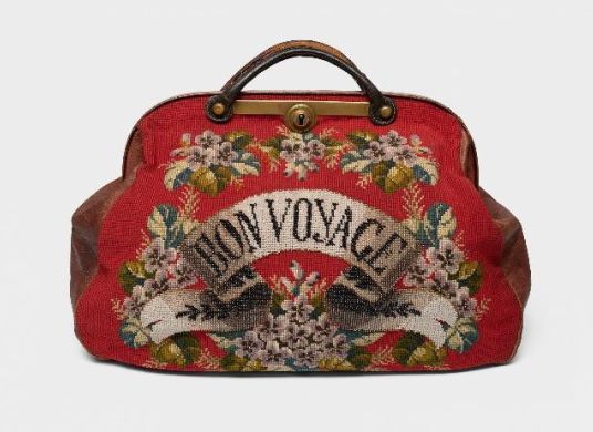 Rote Tasche mit Blumenstickereien und der Aufschrift "Bon Voyage"