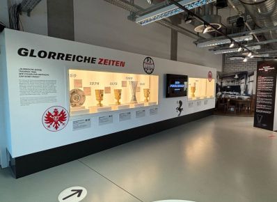 Vitrine im Eintracht Museum mit Pokalen mit der Überschrift "Glorreiche Zeiten" und Jahreszahlen